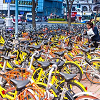 Large amount of yellow bicycles parked on sidewalk